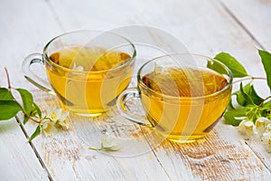 Two cups of green tea with jasmine flowers