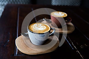 Two Cups of hot cappuccino on wooden desk background.