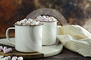 Two cups of hot chocolate, cocoa or warm drink with marshmallows on dark background