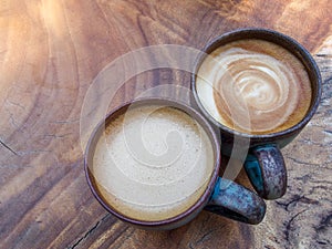 Two cups of hot coffee cappuccino on wood texture background in