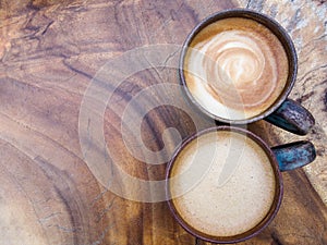 Two cups of hot coffee cappuccino on wood texture background, to