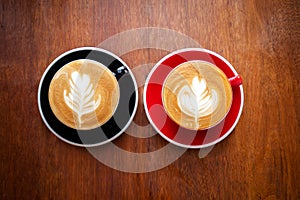 Two cups of hot coffee with latte art on wooden table. Favorite beverage of caffein drink