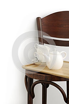 Two cups and pot on brown chair