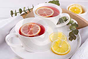 Two cups of red fruit and herbal tea with lemon slice