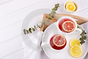 Two cups of red fruit and herbal tea with lemon slice,