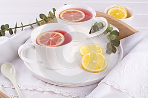 Two cups of red fruit and herbal tea with lemon slice,