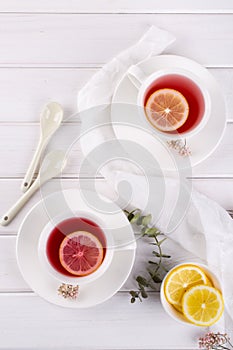 Two cups of red fruit and herbal tea with lemon slice,