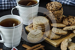Two cups of tea and various cookies