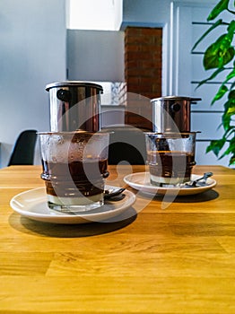 Two cups with Vietnamese coffee, standing on a small table