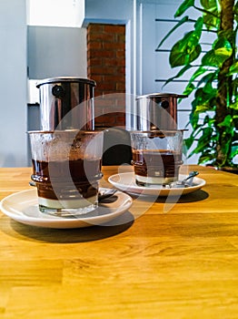 Two cups with Vietnamese coffee, standing on a small table