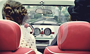 Two curly girl in medieval dress in vintage cars. Vintage style.