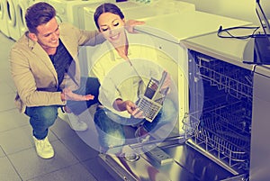 Two customers choosing new dish washing machine