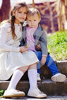 Two cute adorable siblings  hugging on the street