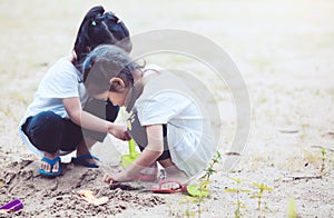 Two cute asian little child girls having fun to play with sand