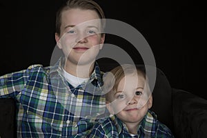 Two cute brothers portrait wearing matching shirts smiling at ca