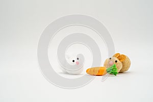 Two cute brown and white rabbit pom pom toys with carrot isolate