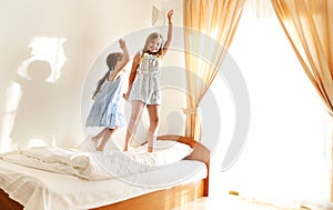Two cute carefree little sisters girls in casual clothes playing having fun in childrens room