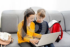 Two cute child girls using laptop together with fun and happiness