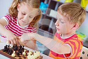 Two cute children plaing chess