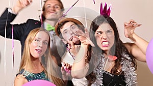 Two cute couples making funny faces in party photo booth