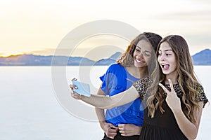 Two cute and diverse teenage girls posing and taking a selfie together outdoors