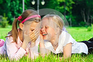 Two cute girls laughing on the grass photo