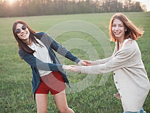 Two girls dancing at sunset