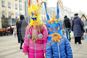 Two cute girls wearing frightening masks during the celebration of Uzgavenes, a Lithuanian annual folk festival taking place seven