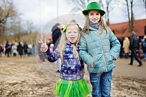 Two cute girls wearing green hats and accessories celebrating St. Patrick`s day in Vilnius.