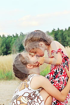 Two Cute happy little girls is smiling and hugging  on summer filed