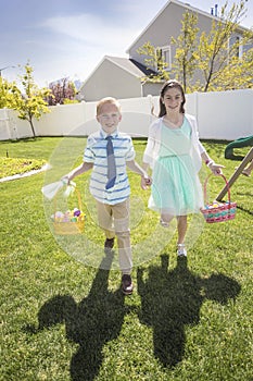 Two cute kids enjoying an Easter Egg Hunt Outdoors