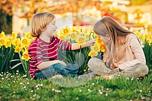 Two cute kids, little boy and his big sister, playing in the park