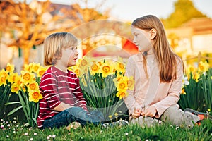 Two cute kids, little boy and his big sister, playing in the park