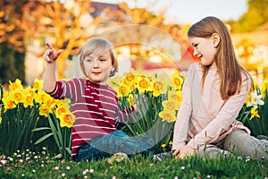 Two cute kids, little boy and his big sister, playing in the park