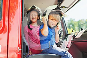 Two cute kids playing in fire truck