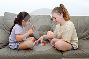 Two cute kids playing with flexible toy the Pop It fidget.