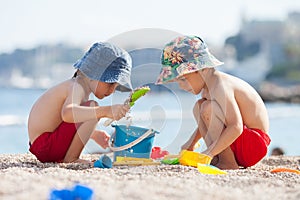 Two cute kids, playing in the sand on the beach