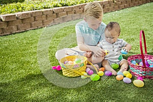 Two Cute little boys collecting eggs on an Easter Egg hunt outdoors