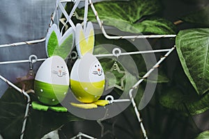 Two cute little easter bunnies hanging from an easter tree