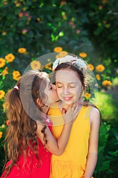 Two Cute little girls embracing and smiling at summer party. Happy kids outdoors. Place for text