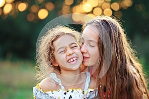 Two Cute little girls hugging and laughing at the countryside. Happy kids spending time outdoors