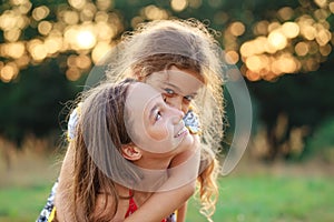 Two Cute little girls hugging and smiling at the countryside. Happy kids spending time  outdoors