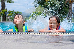Two cute little girls playing in the pool. Summer lifestyle concept