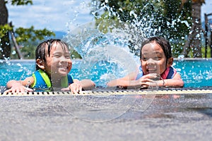 Two cute little girls playing in the pool. Summer lifestyle concept