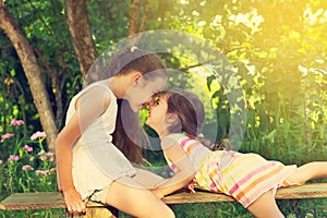 Two cute little girls smiling and playing at the park. Toned.