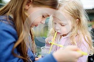 Two cute little sisters drinking frozen slushie drink