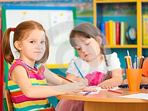 Two cute preschool girls at drawing lesson