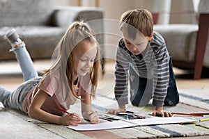 Two cute sibling preschooler kids drawing in paper albums