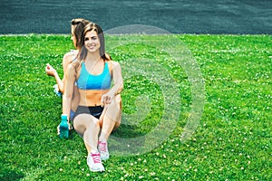 Two cute sporty girls relaxing after workout outdoor