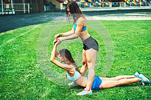 Two cute sporty girls workout together outdoor